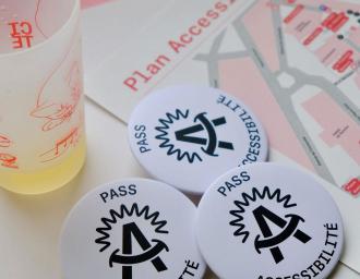 Vue sur les badges "Pass accessibilité" et le plan du festival de la cité