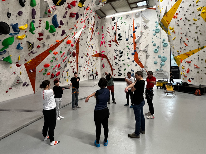 Groupe de membres et formateurs de la FSA réunis au sol pour une séance d'étirements collectifs après l'effort.