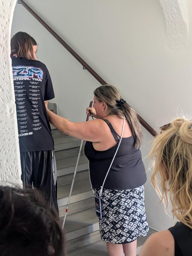 Sabrina Faretra sensibilise un bénévole au guidage dans des escaliers